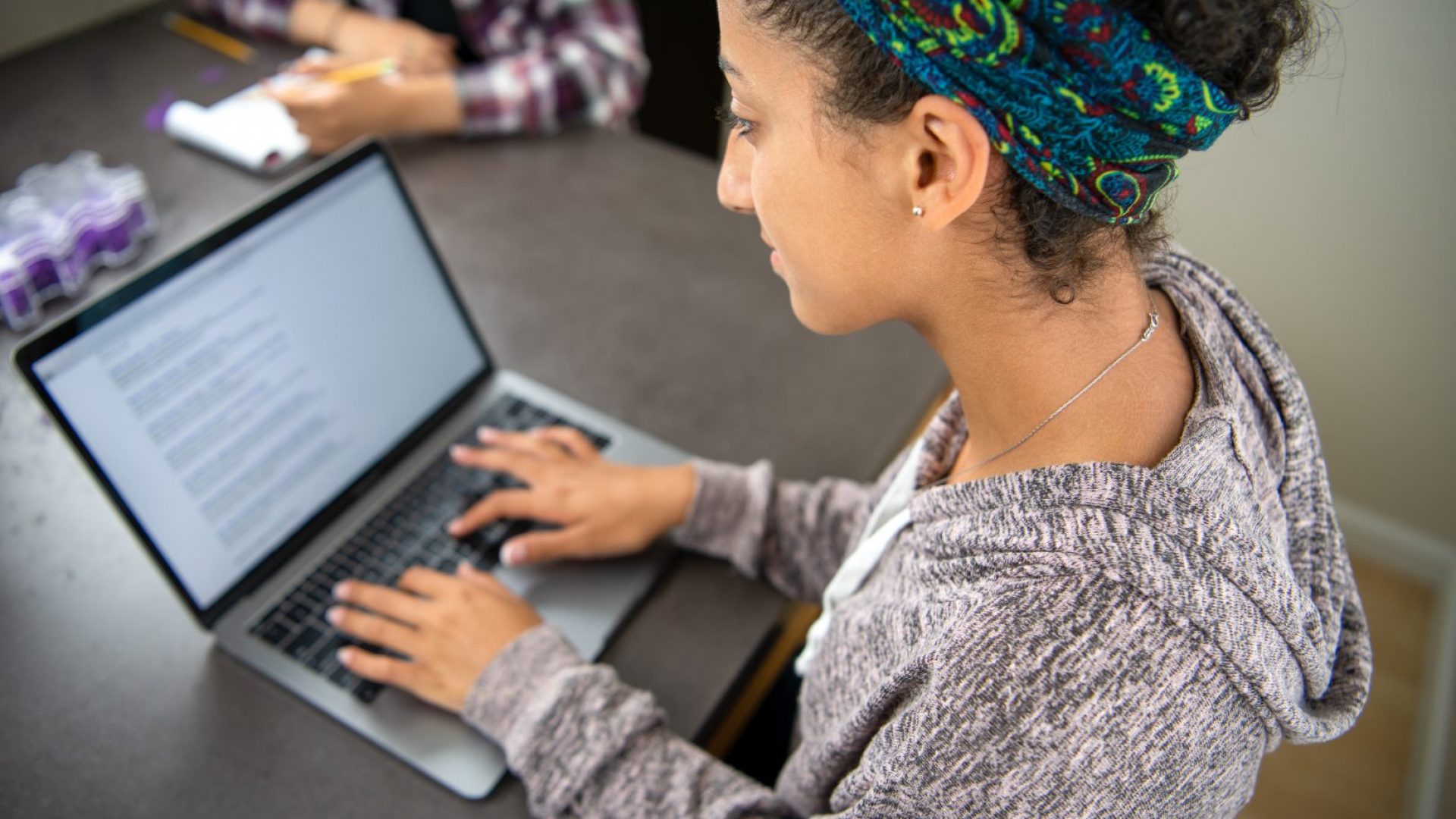 High school student girl learning online, doing research, and working on homework using a laptop computer