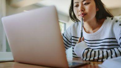 Asian woman studying at home using laptop