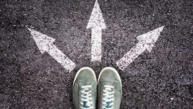 Shoes and arrows pointing in different directions on asphalt floor