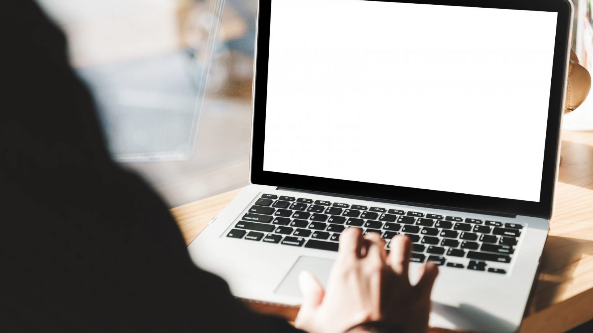 Man using laptop with blank screen at table in the office