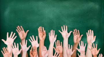 Multiethnic Group of Hands Raised with Blackboard